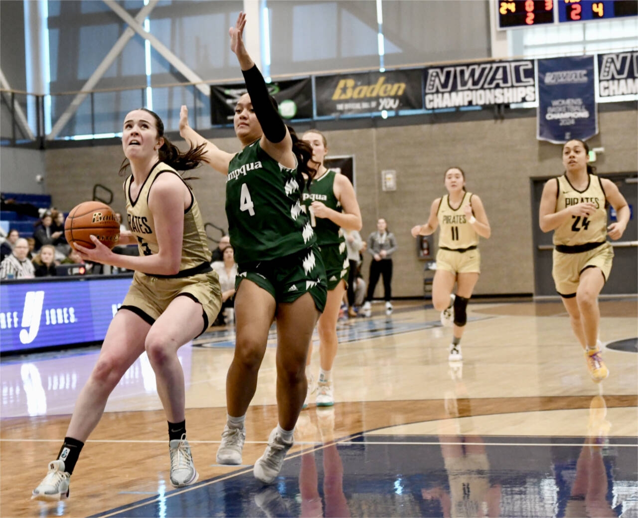 Peninsula College’s Alexa Mackey goes to the rim up against Umpqua’s Amaya Afatasi (4) on Saturday in Pasco. Trailing the play are Peninsula’s Jenilee Donovan (11) and Shania Moananu (24). Umpqua won 73-55. (Jay Cline/Peninsula College)