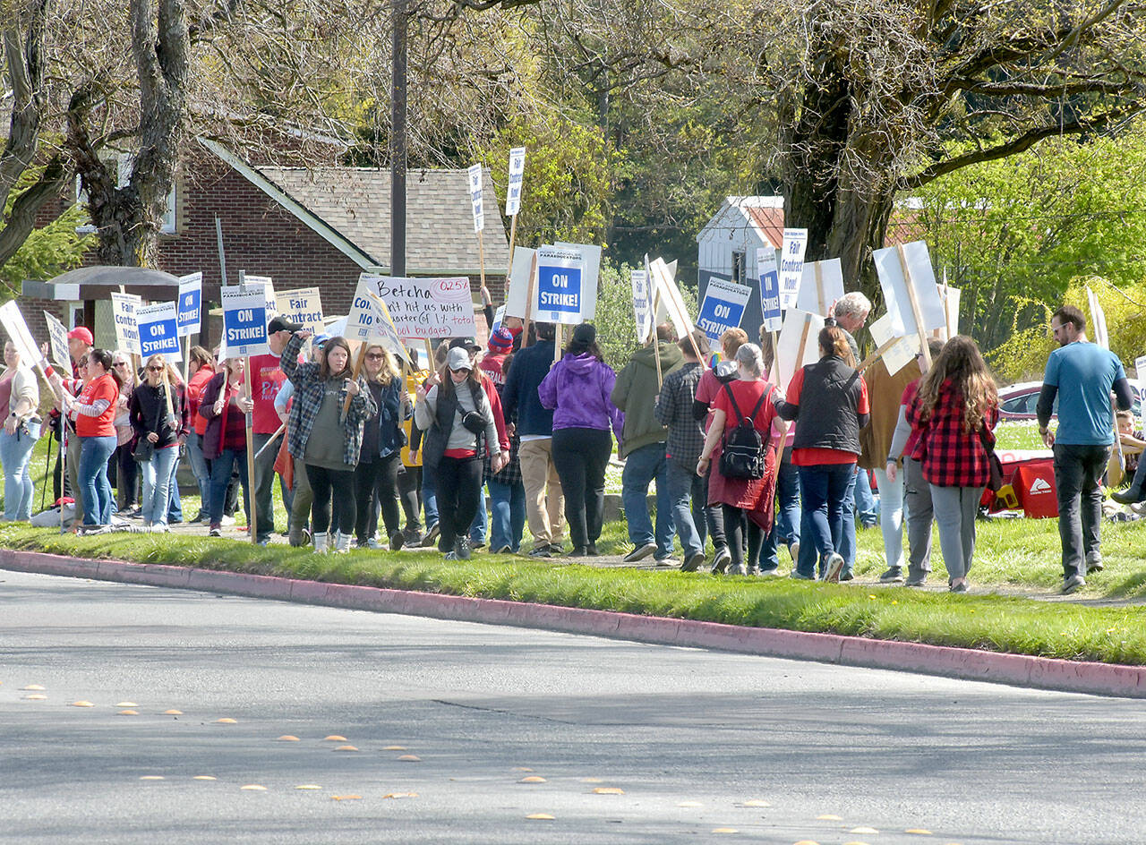 Pickets in support of paraeducators in the Port Angeles School District march along West Eighth Street in front of the district offices at Lincoln Center on Wednesday. (Keith Thorpe/Peninsula Daily News)
