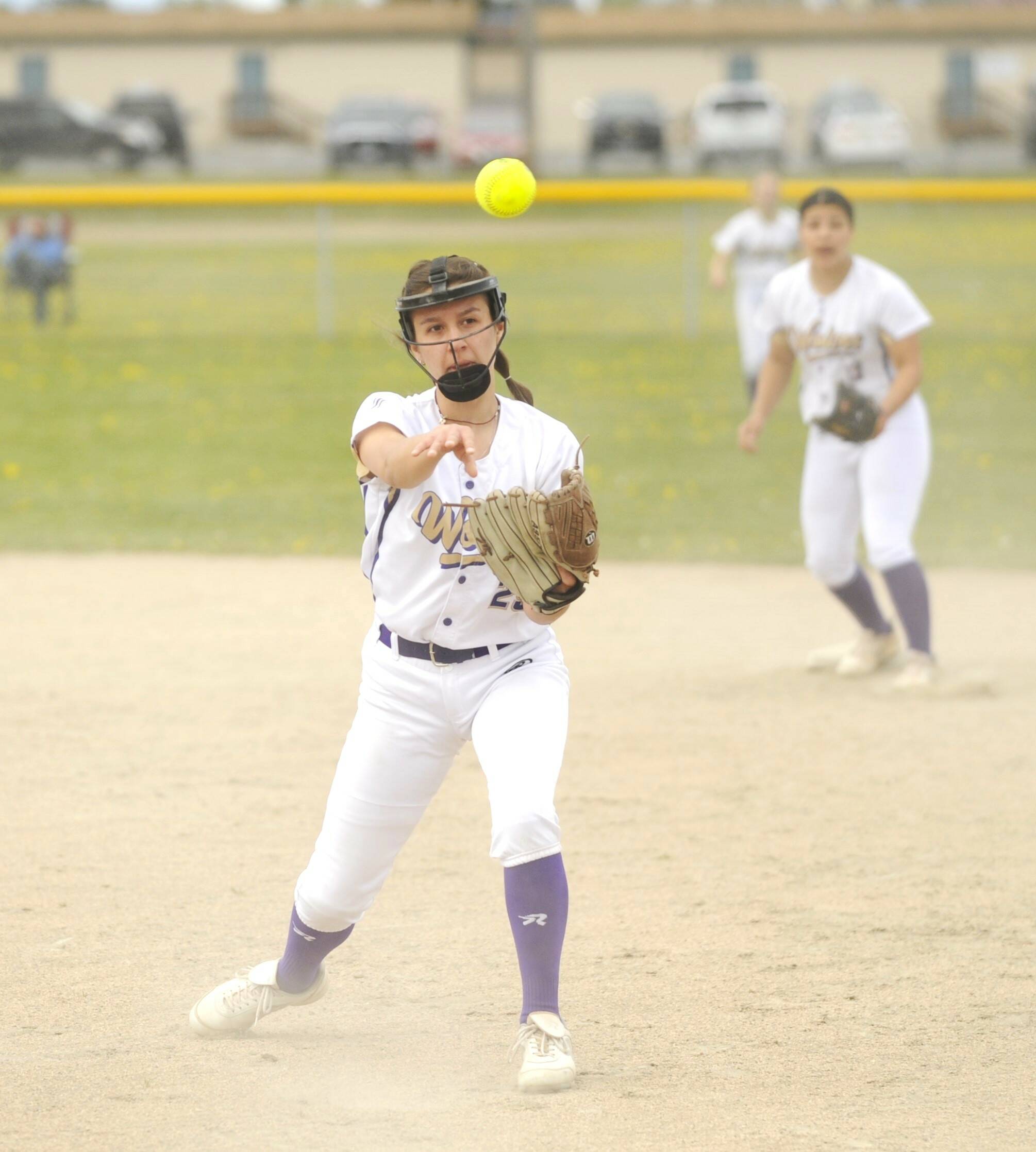 With teammate Taylee Rome looking on, Sequim second baseman Mia Kirner throws out a Klahowya runner in a non-league match-up Saturday. Kirner had a home run in the windy game. (Michael Dashiell/Olympic Peninsula News Group)