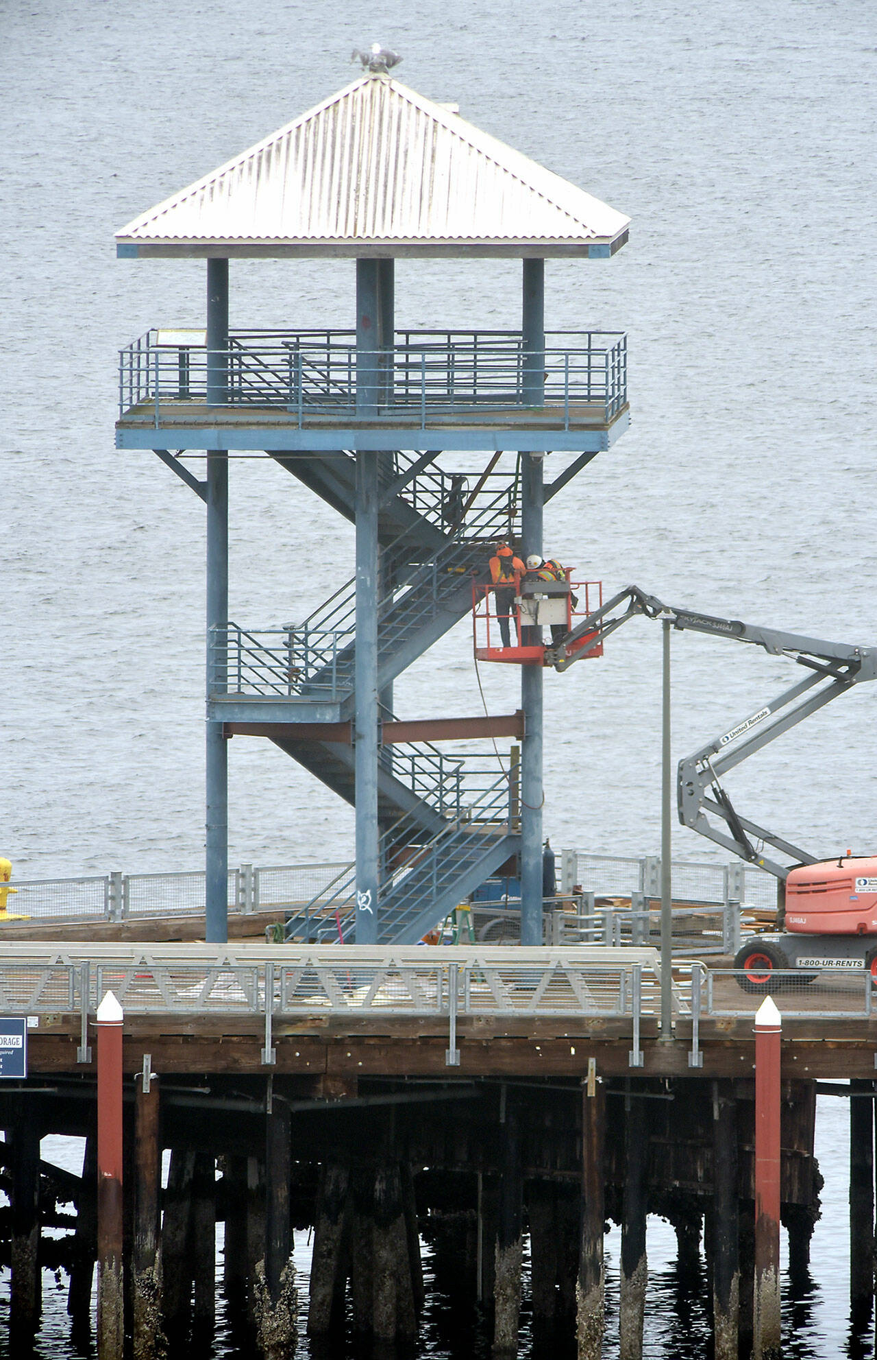 A repair crew performs work on the observation tower at the end of Port Angeles City Pier on Wednesday as part of a project to repair structural deficiencies in the tower, which has been closed to the public since November. The work, being performed by Aberdeen-based Rognlin’s Inc., includes replacement of bottom supports and wood decking, paint removal and repainting of the structure. Work on the $574,000 project is expected to be completed in June. (Keith Thorpe/Peninsula Daily News)