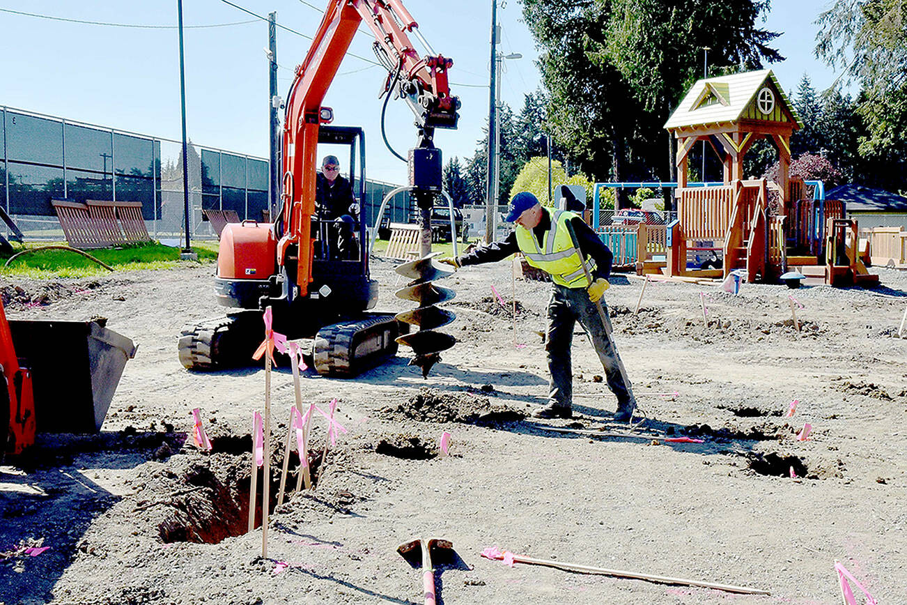 Volunteer Al Oman, right, guides an auger operated by Steve Fink during site preparation for rebuilding the Dream Playground on Wednesday at Erickson Playfield in Port Angeles. A community rebuild is scheduled for May 15-19 to replace portions of the popular playground that were destroyed in an arson fire on Dec. 20. Volunteer signups are available at https://www.padreamplayground.org. The nonprofit Dream Playground Foundation, which organized and orchestrated previous versions of the playground, is also seeking loaner tools with more information available at https://www.signupgenius.com/go/904084DA4AC23A5F85-48241857-dream#/. (Keith Thorpe/Peninsula Daily News)