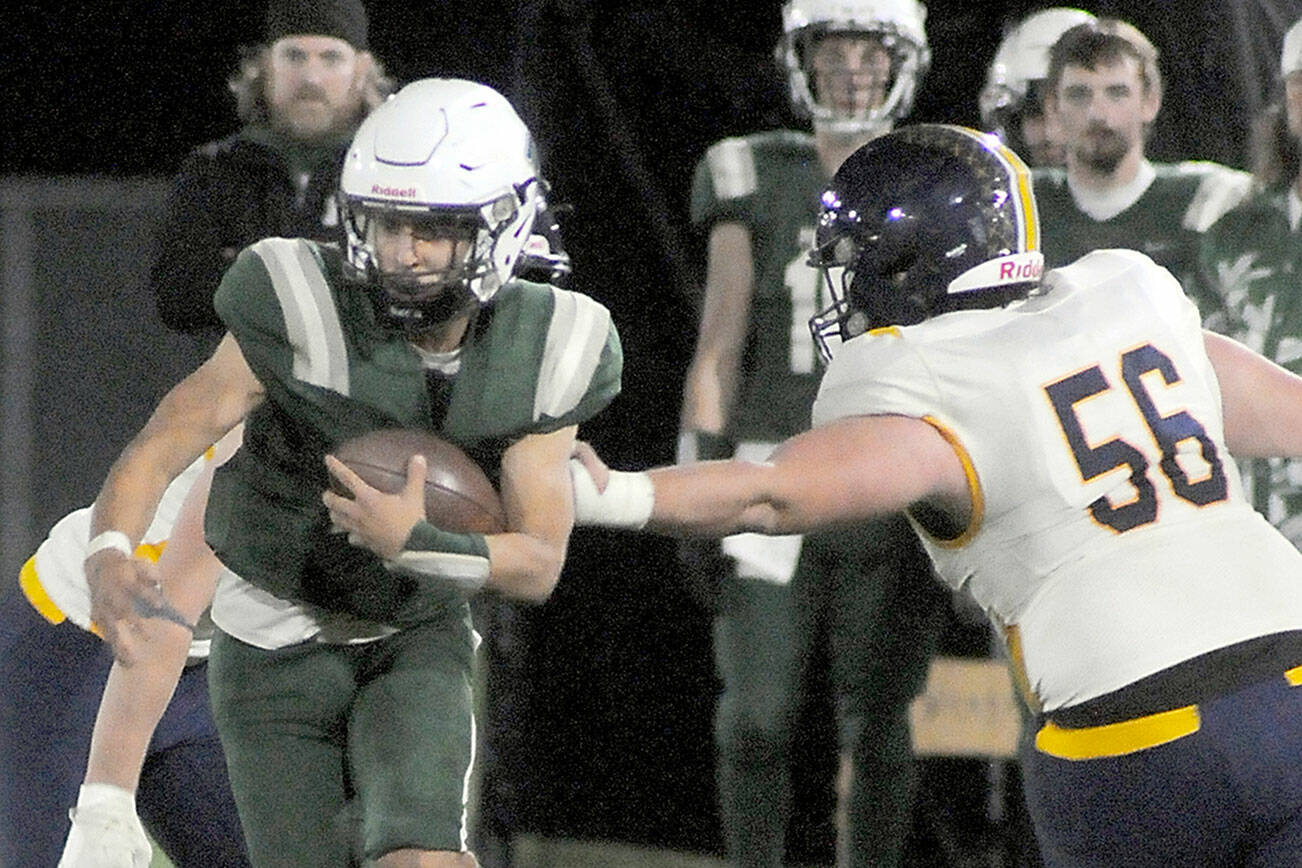 KEITH THORPE/PENINSULA DAILY NEWS
Port Angeles' Kason Albaugh tries to evade the defense of Bainbridge's Emmett Taylor on Friday night at Port Angeles Civic Field.