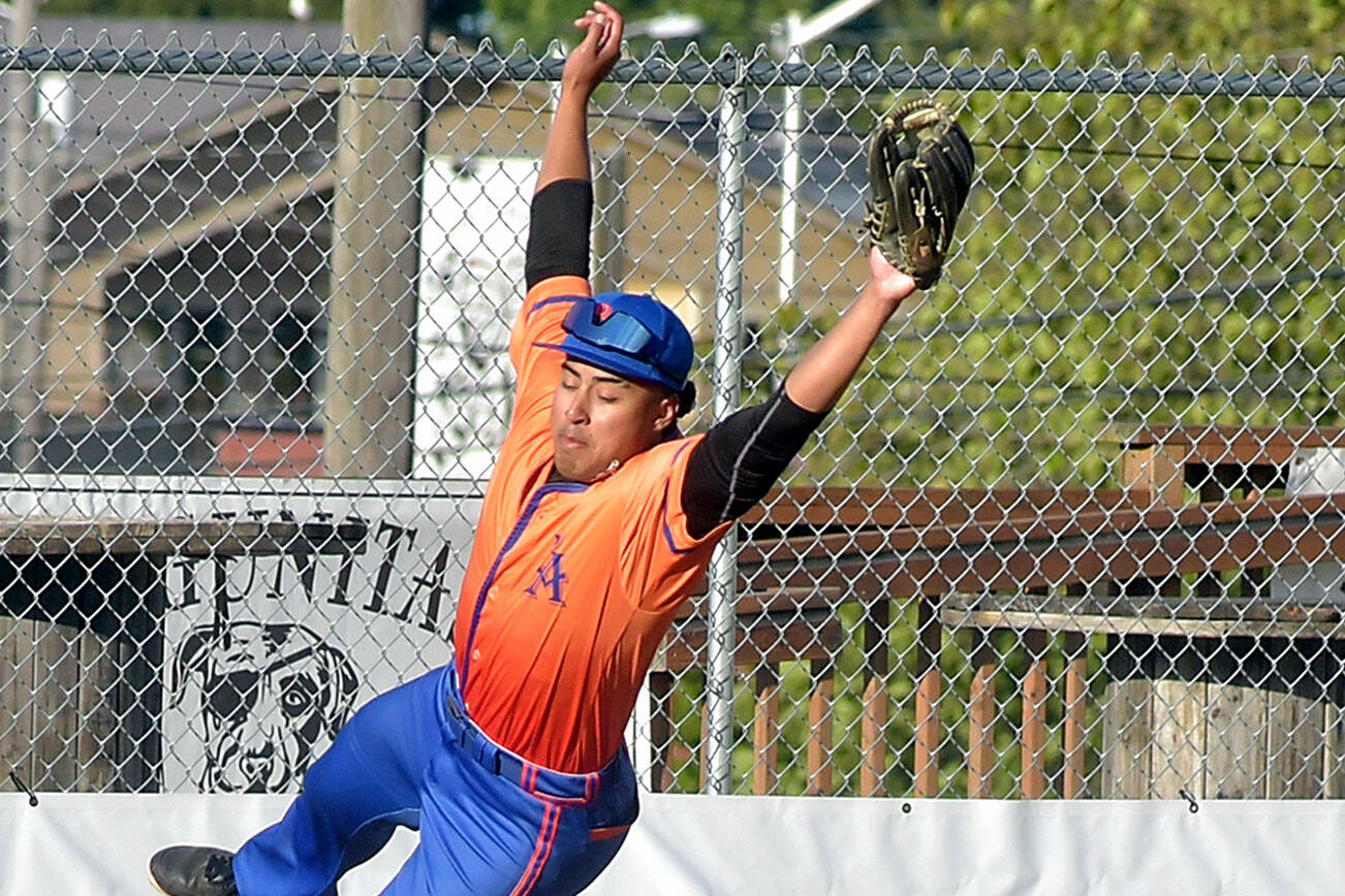 KEITH THORPE/PENINSULA DAILY NEWS
Lefties third baseman Roberto Nunez leaps for a wild throw as Redmond baserunner Charlie Deggeller makes it to the bag on Wednesday's season opener at Port Angeles Civic Field.