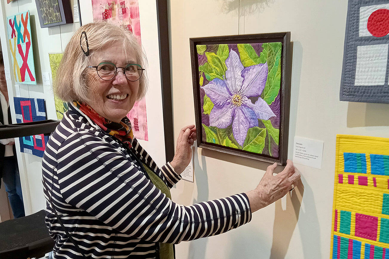 Liisa Fagerlund with a bead-embellished floral image on display at the A. Milligan Gallery on North Sequim Avenue.
