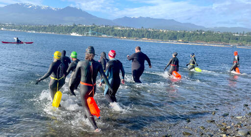 Competitors in the second annual Orca Bait Swim enter Port Angeles Harbor on Sunday for the 1.5-mile race from the Sail & Paddle Park on Ediz Hook to Pebble Beach Park. The start was relocated from the boat ramp near the U.S. Coast Guard station due to rough water and a large vessel anchored near the finish. All 10 swimmers — nine women and one man — completed the race. (Paula Hunt/Peninsula Daily News)