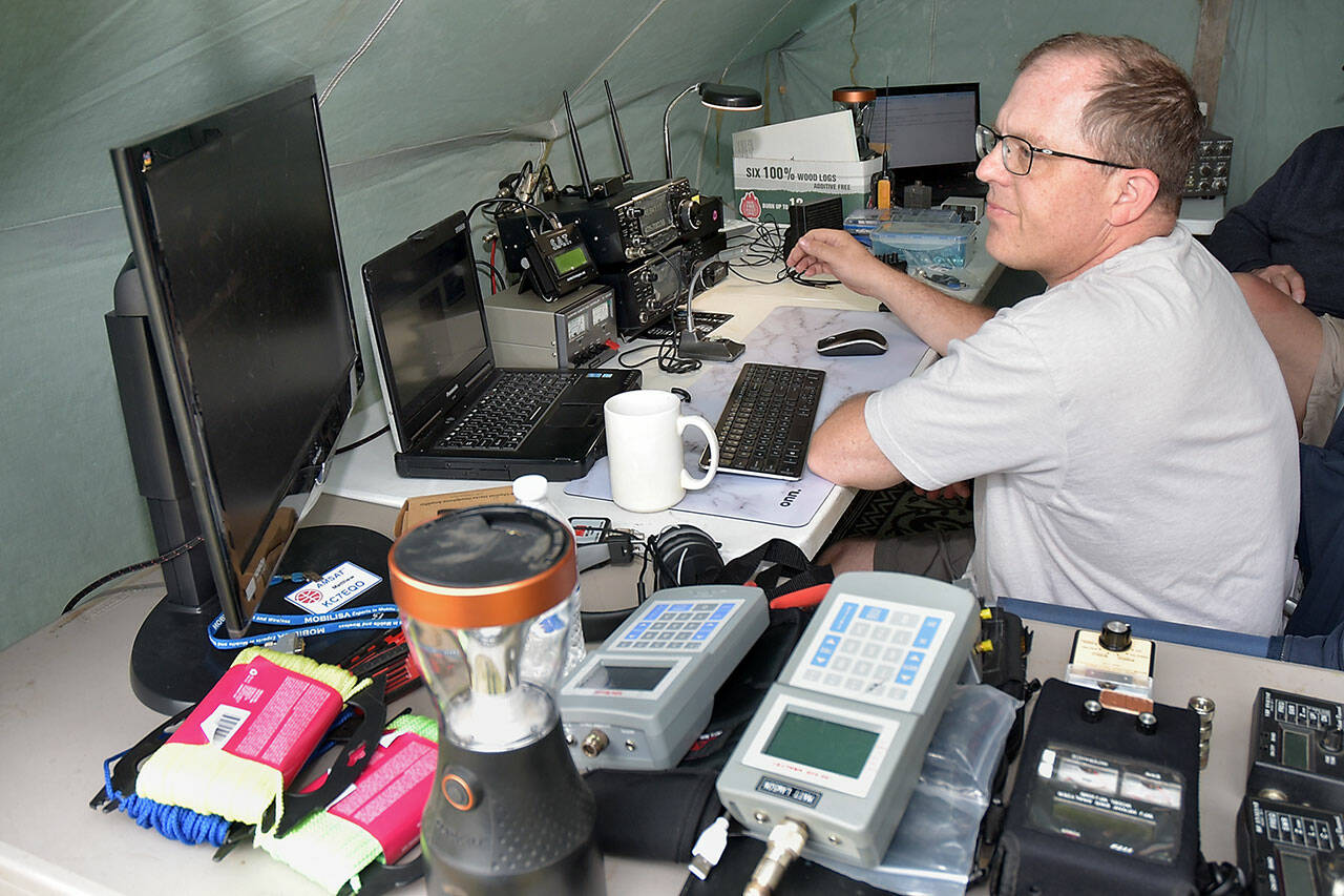Matt Larson of Sequim, who uses the radio call sign KC7EQO, tunes into a ham radio satellite during Saturday’s Radio Field Day at the Clallam County Fairgrounds in Port Angeles. The annual event, hosted by the Clallam County Amateur Radio Club, brought together amateur radio operators from around the world in a contest to make as many radio contacts as possible in a 24-hour period as a test of emergency preparedness from remote locations. (Keith Thorpe/Peninsula Daily News)