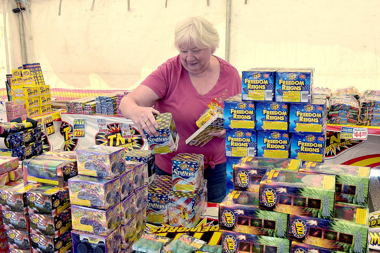 Marie Moran of Port Angeles looks over a selection of fireworks available at the TNT Fireworks stand operated by the Seattle International Christian Church in the parking lot of the Safeway store at 2709 E. Highway 101 near Port Angeles on Tuesday. In Clallam County, the discharge of consumer fireworks are allowed between 9 a.m. and midnight on Thursday for areas east of the Elwha River and at all times west of the Elwha. They are banned in the cities of Port Angeles and Sequim. In Jefferson county, fireworks are banned in the city of Port Townsend and allowed in most other areas with hours limited to 9 a.m. to 11 p.m. today and Friday, and from 9 a.m. to midnight on Independence Day. (Keith Thorpe/Peninsula Daily News)
