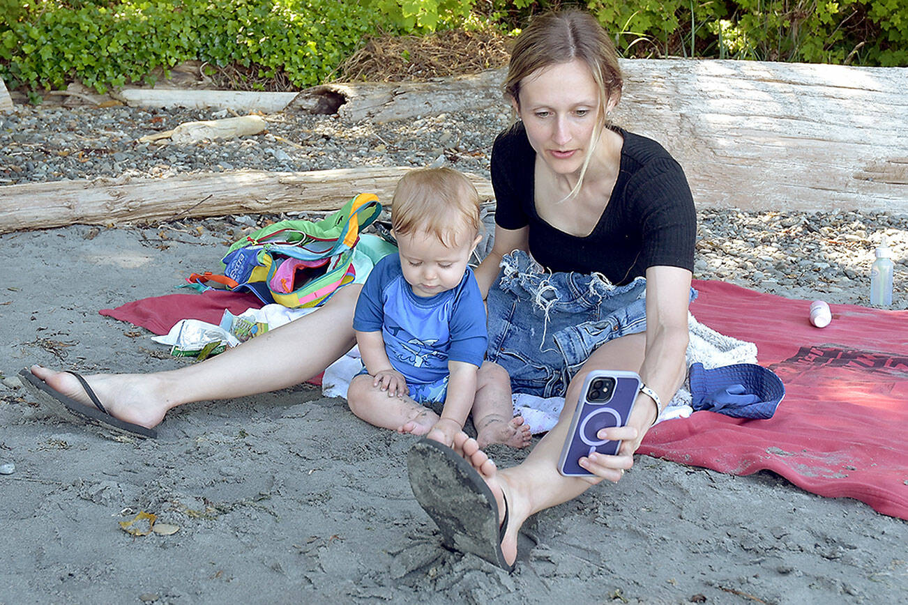 Kara Wolfe of Puyallup and her son, Eli, 11 months, take a selfie on the beach at Freshwater Bay west of Port Angeles on a sunny Saturday. Temperatures in the upper 70s to low 80s across the North Olympic Peninsula found many people looking for ways to beat the heat as summer conditions rolled across the region. (Keith Thorpe/Peninsula Daily News)