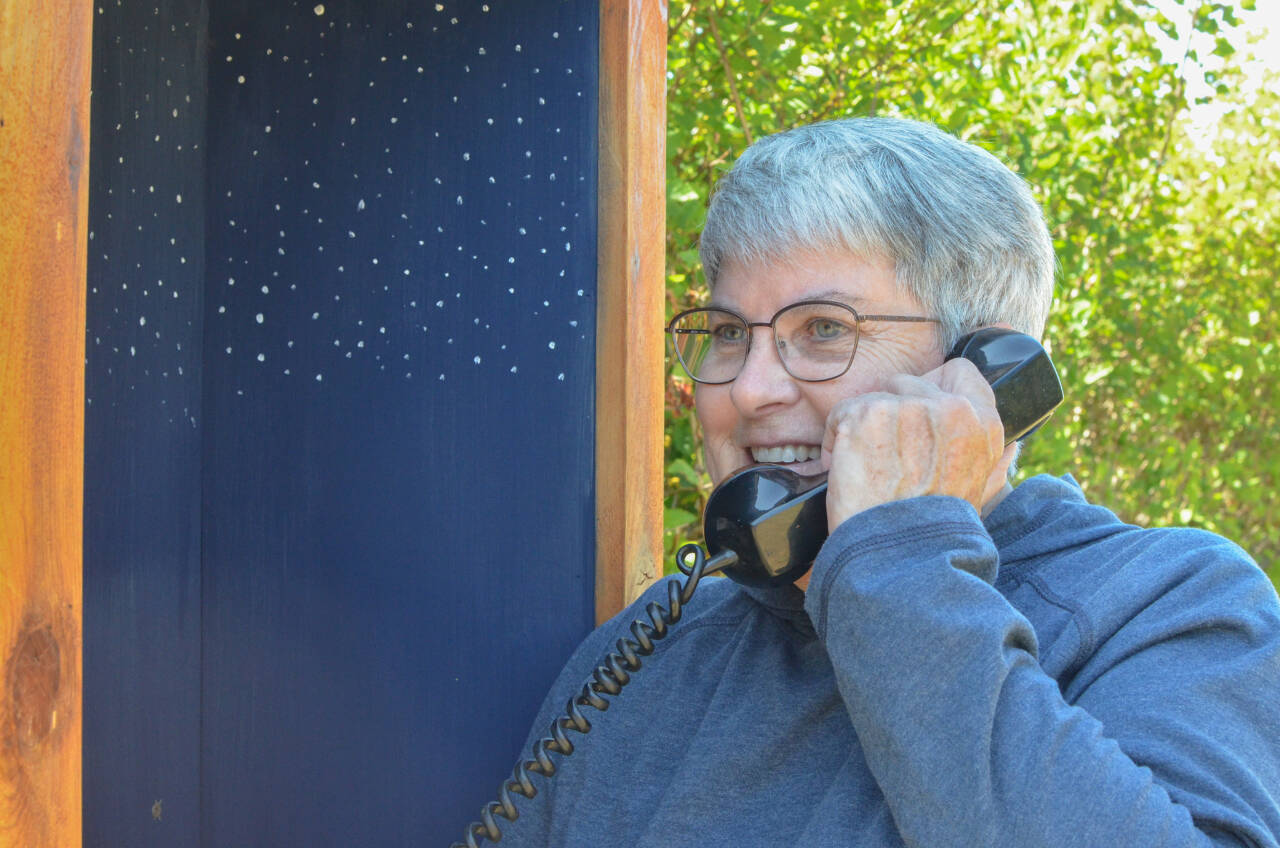 Diane Fatzinger uses the wind phone in Sequim, located just north of the Olympic Discovery Trail on West Hendrickson Road. (Elijah Sussman/Olympic Peninsula News Group)