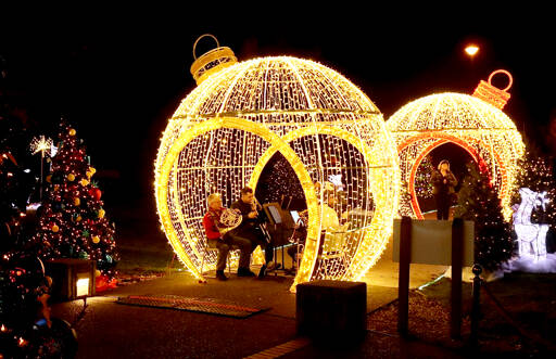 The outside of the Vern Burton Community Center is decorated with giant Christmas balls and lighted trees on Wednesday for the opening ceremonies of the Festival of Trees. “White Christmas” was played by the Port Angeles Symphony Orchestra’s brass quintet and then sung by Amanda Bacon. (Dave Logan/for Peninsula Daily News)