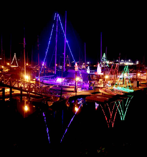 Many colorful Christmas lights that adorn sailboats reflect in the calm waters at Port Angeles Boat Haven. The weather forecast predicts high temperature in the low 50s across the Peninsula this weekend with an increased chance for showers on Saturday and Sunday. (Dave Logan/for Peninsula Daily News)