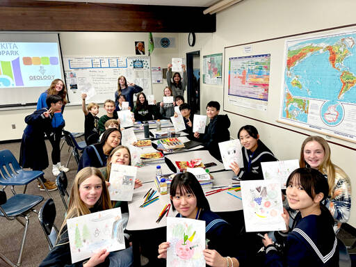 Students from Mutsu City, Japan, and Port Angeles sit in a Stevens Middle School classroom eating lunch before the culture fair on Tuesday. To pass the time, they decided to have a drawing contest between themselves. (Rob Edwards)