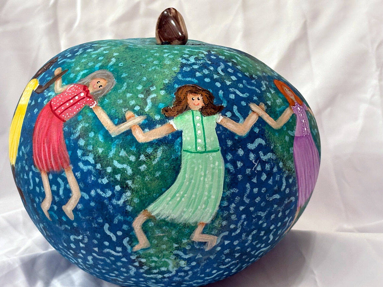Jane Smith uses gourds as her canvas. She uses a wide variety of techniques and embellishments in her designs, and the trinkets she uses to enhance her work come from her lifetime of collecting.