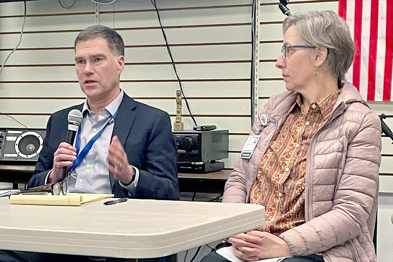 Olympic Medical Center CEO Darryl Wolfe, left, and board President Ann Henninger present information and answer questions about the hospital’s exploration of a possible partnership with another health care system at a forum held by the Clallam County Democrats. Aligning with another organization could help address OMC’s financial challenges and meet community care needs, Wolfe said. (Paula Hunt/Peninsula Daily News)