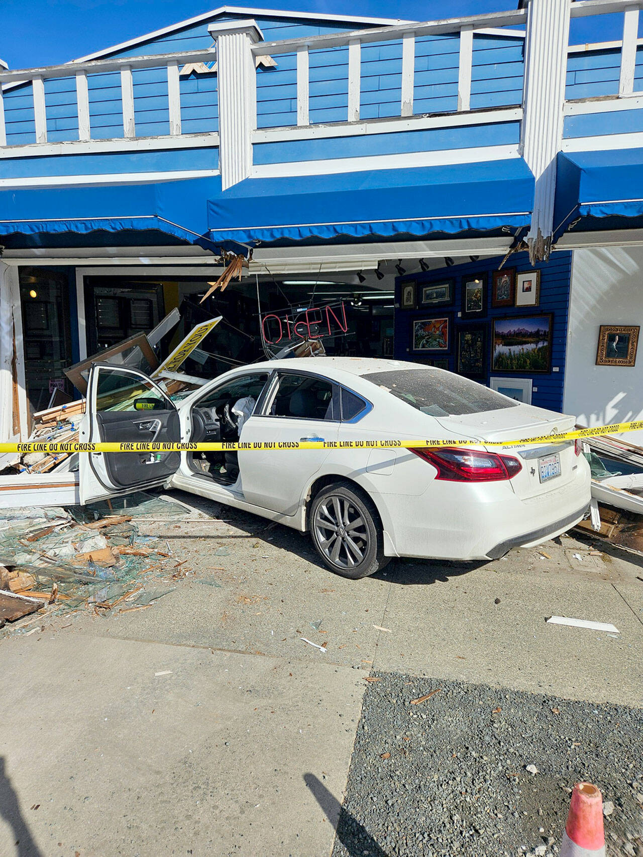 Port Angeles police officers and firefighters responded Friday after a car when into a building in the 600 block of East Front Street. Traffic was disrupted until the vehicle could be cleared from the scene, police said. (Port Angeles Police Department)
