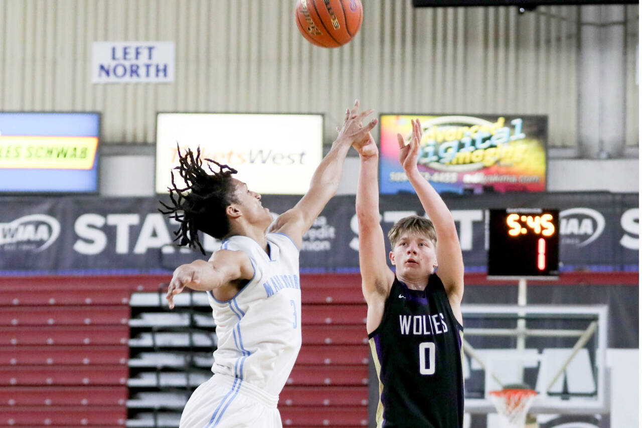 Sequim’s Ethan Melnick (0) shoots a three over Dalton Stevens’ outstretched hand during Sequim’s 69-59 loss to Mark Morris in a Round of 12 game at the 2A state tournament at the Yakima Valley SunDome on Wednesday. (Dylan Wilhelm /Daily Chronicle)