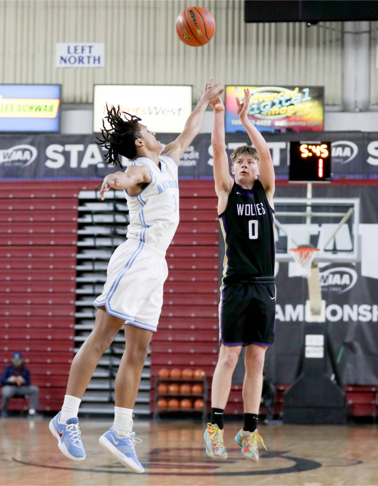 Sequim’s Ethan Melnick (0) shoots a three over Dalton Stevens’ outstretched hand during Sequim’s 69-59 loss to Mark Morris in a Round of 12 game at the 2A state tournament at the Yakima Valley SunDome on Wednesday. (Dylan Wilhelm /Daily Chronicle)