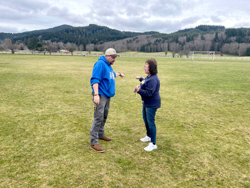 Quillayute Valley School District maintenance and facilities manager Bill Henderson, left, and Superintendent Diana Reaume check out the site on campus where new softball and baseball fields will be constructed. The $3 million project is scheduled to open sometime in 2026. (Paula Hunt/Peninsula Daily News)
