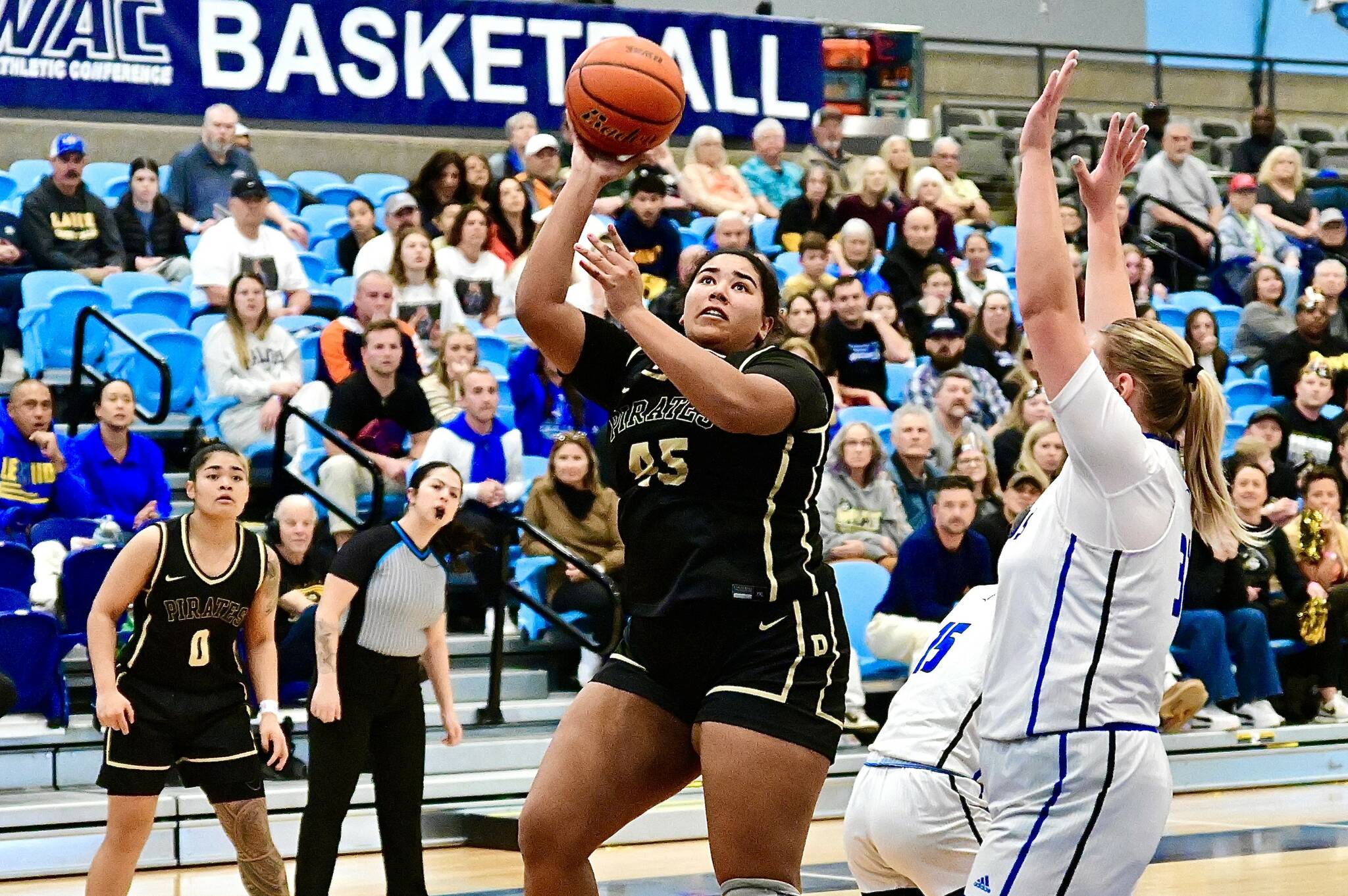 Peninsula College's Jelissa Julmist (Sequim High School) goes up for a basket against Lane in the NWAC semifinals held in Pasco on Saturday. Defending NWAC champion Lane hit 12 3-pointers and won 80-63, the Titans' 45th win in a row as the Pirates' season ends with a 24-3 record. In on the play is Peninsula's Ciera Tugade Agasiva. (Jay Cline/Peninsula College).
