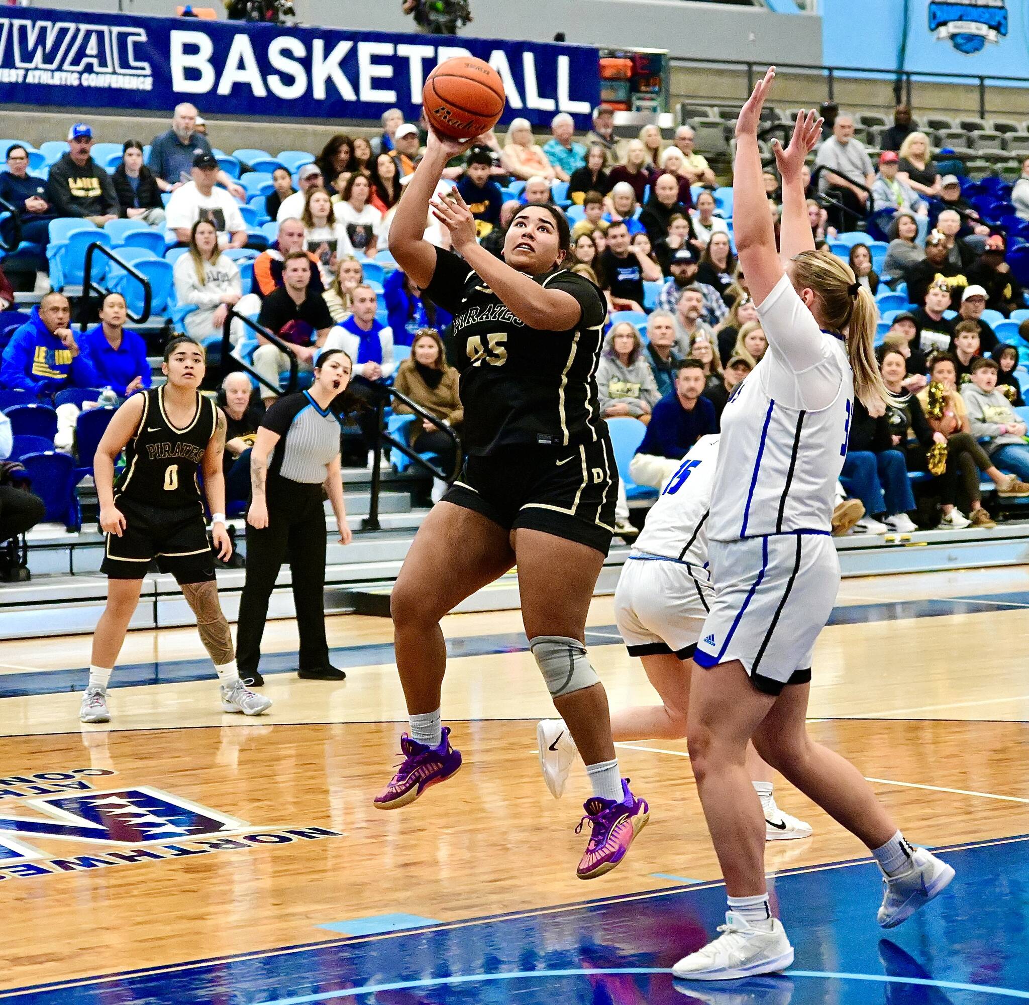Peninsula College’s Jelissa Julmist (Sequim High School) goes up for a basket against Lane in the NWAC semifinals held in Pasco on Saturday. Defending NWAC champion Lane hit 12 3-pointers and won 80-63, the Titans’ 45th win in a row as the Pirates’ season ends with a 24-3 record. In on the play is Peninsula’s Ciera Tugade Agasiva. (Jay Cline/Peninsula College).
