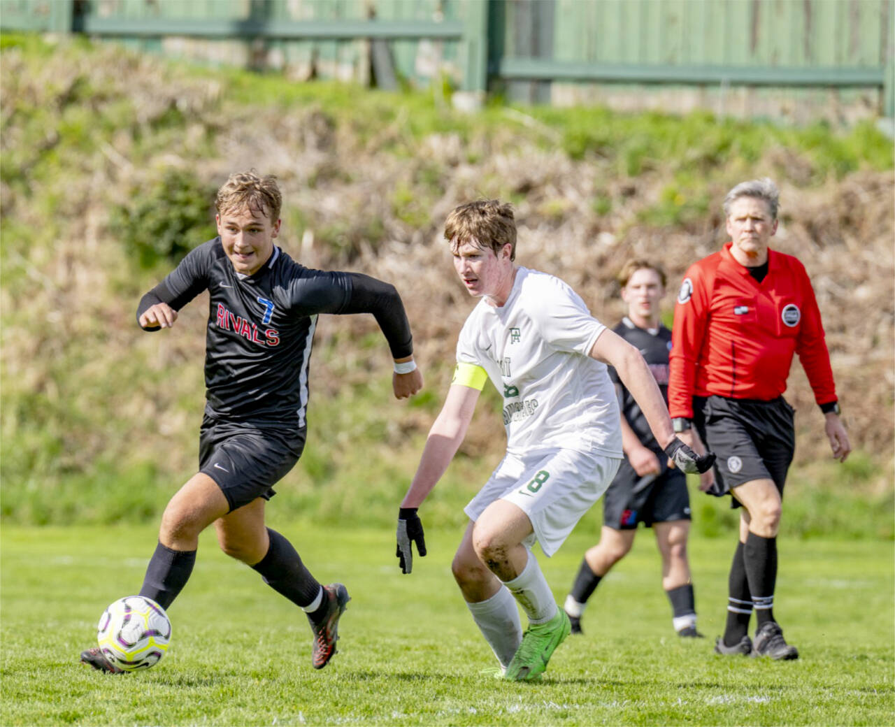 East Jefferson’s Jameson Henery, 7, races Port Angeles Roughrider Jacob Weaver for control of the ball during a non-league game on Saturday at Memorial Field in Port Townsend. The Rivals scored two late goals to win 3-2. (Steve Mullensky/for Peninsula Daily News)