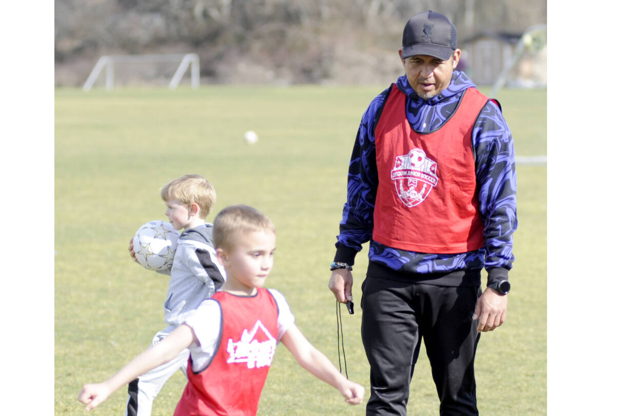 Matthew Nash/Olympic Peninsula News Group
Juan Carlos Cisneros-Lopez, Sequim Junior Soccer’s new director of coaching, works with players, such as Barrett Gerdes, 6-and-a-half, at a preseason skills camp on March 1 at the Albert Haller Playfields. In the coming months, Cisneros-Lopez said he plans to develop a curriculum for players and coaches to succeed.