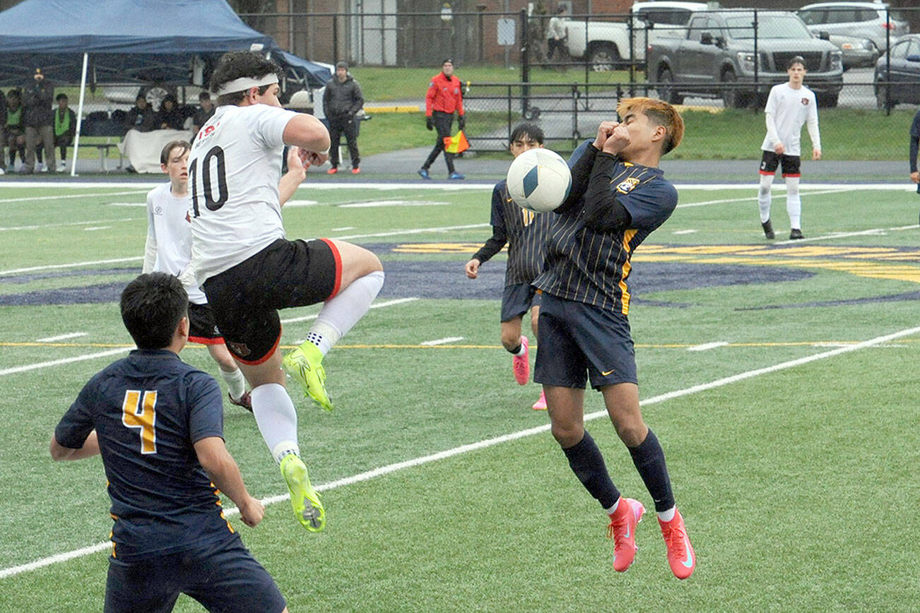 Lonnie Archibald/for Peninsula Daily News
Beaver Miquel Espinoza (10) and Spartan Abraham Montealegre (right) compete for ball control Monday evening on the turf of Spartan Stadium where Forks defeated Tenino 4-0. In on the play is Forks' Eduardo Calmo, 4, and Margarito Gonzalez Black, 11.