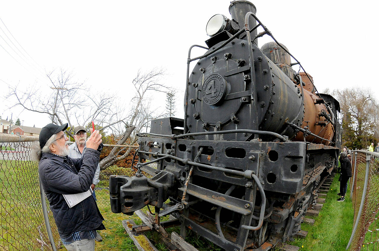 Gary Norris, front, takes a photo of the Rayonier No. 4 as Leo Frymire looks on during a tour of the engine on Sunday at Lauridsen Boulevard and Chase Street in Port Angeles. They attended a fundraiser for Restore the 4!, a local group leading the effort to restore the geared locomotive built in 1924 by Willamette Iron and Steel in Portland, Ore. The North Olympic History Center, which helped organize the event, donated $1,000 toward the cause. More than 100 people attended a presentation by Steve Hauff, a local historian and expert on Willamette logging locomotives, at the Port Angeles Main Library beforehand. (Keith Thorpe/Peninsula Daily News)