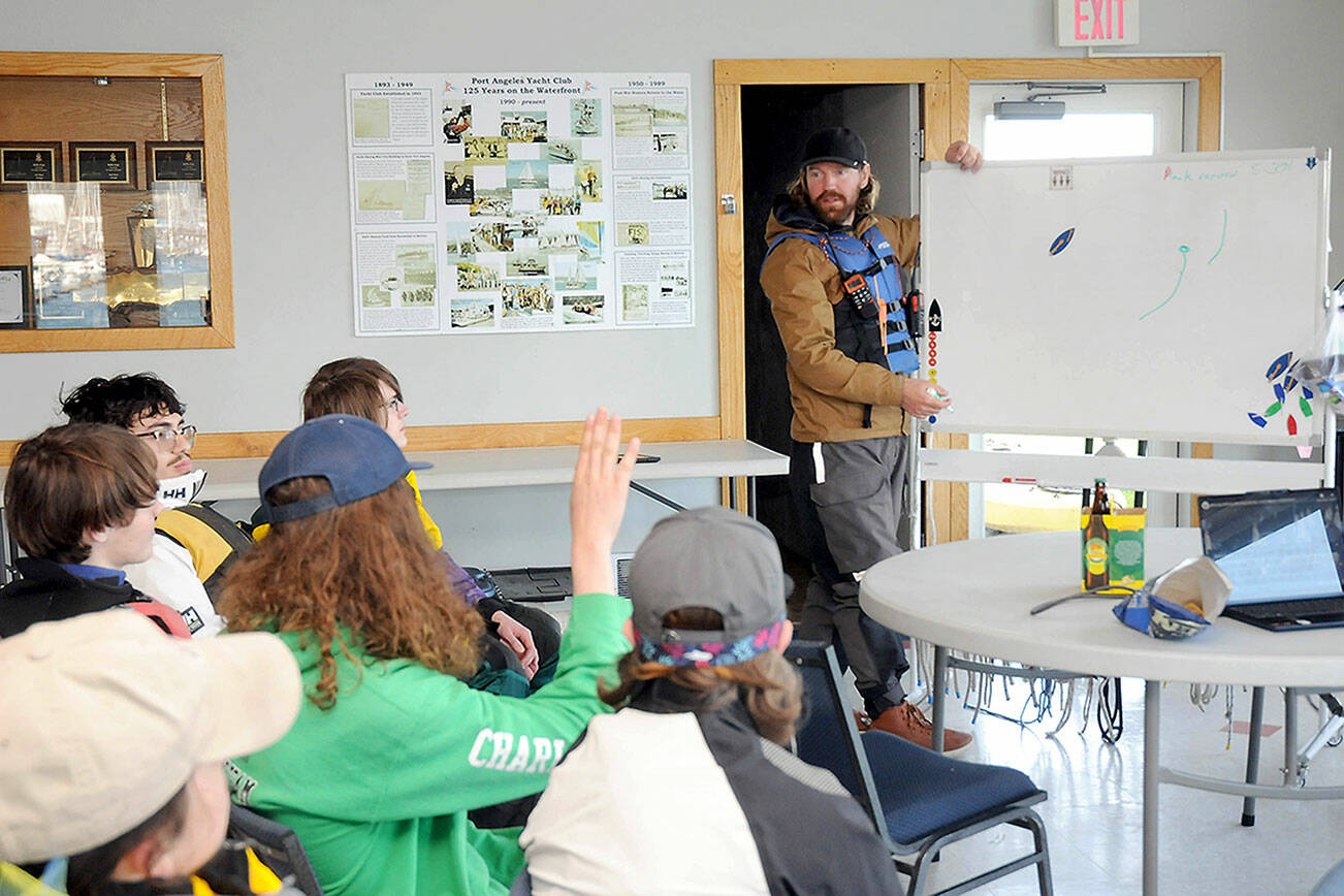Boating coach Eric Lesch, at a whiteboard, explains sailing techniques to a youth sailboat class. (Keith Thorpe/Peninsula Daily News)