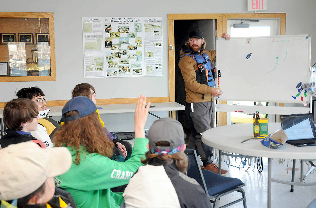 Boating coach Eric Lesch, at a whiteboard, explains sailing techniques to a youth sailboat class. (Keith Thorpe/Peninsula Daily News)