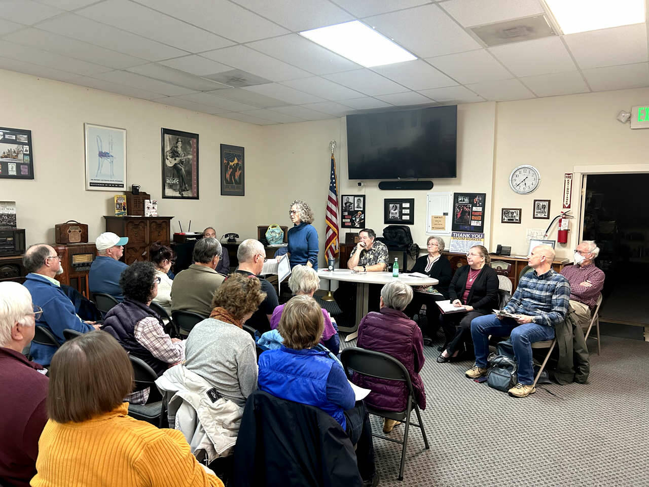 Susan Fisch, standing, chair of the Clallam County Charter Review Commission, addresses a crowd of residents who packed the meeting room at KSQM FM (91.5) last month for the first of several town hall events. Speakers were allowed up to three minutes to share their views about issues related to the charter that they consider most important. (Kathy Cruz/Olympic Peninsula News Group)
