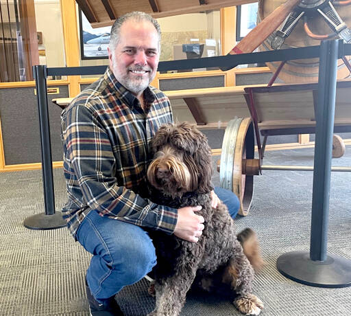 Kelly Kidwell, a local business owner and property developer, is purchasing Rite Bros. with the intention of building a long-term sustainable business that will expand aviation access in the area. Citizen Air, based at William R. Fairchild International Airport, will offer charter flights and fractional aircraft ownership. The possibility of scheduled flights could be in the distant future. Kidwell is shown with his Poodle-Bernese mountain dog, Porter. (Paula Hunt/Peninsula Daily News)