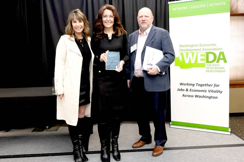 Clallam County Economic Development Council Director of Operations Lorie Fazio, left, and Executive Director Colleen McAleer stand with Michael Cade, executive director of Thurston EDC who presented the WEDA’s 2025 Innovation in Economic Development award. The EDC received the award last month in recognition of its Clallam Forest Product Innovation Program.