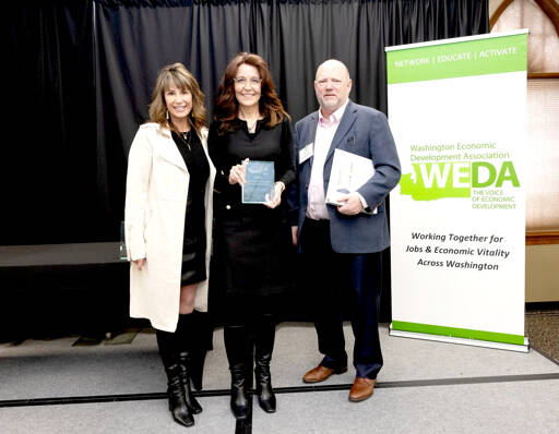 Clallam County Economic Development Council Director of Operations Lorie Fazio, left, and Executive Director Colleen McAleer stand with Michael Cade, executive director of Thurston EDC who presented the WEDA’s 2025 Innovation in Economic Development award. The EDC received the award last month in recognition of its Clallam Forest Product Innovation Program.