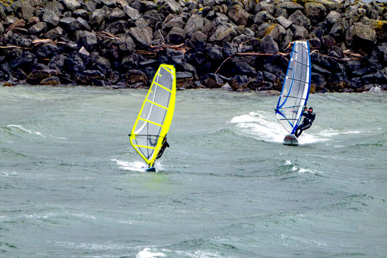 A pair of wind surfers take off from the breakwater at Port Townsend Marina in an apparent race across the bay on Tuesday. (Steve Mullensky/for Peninsula Daily News)