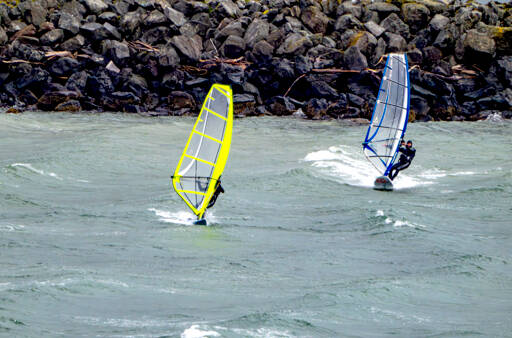 A pair of wind surfers take off from the breakwater at Port Townsend Marina in an apparent race across the bay on Tuesday. (Steve Mullensky/for Peninsula Daily News)