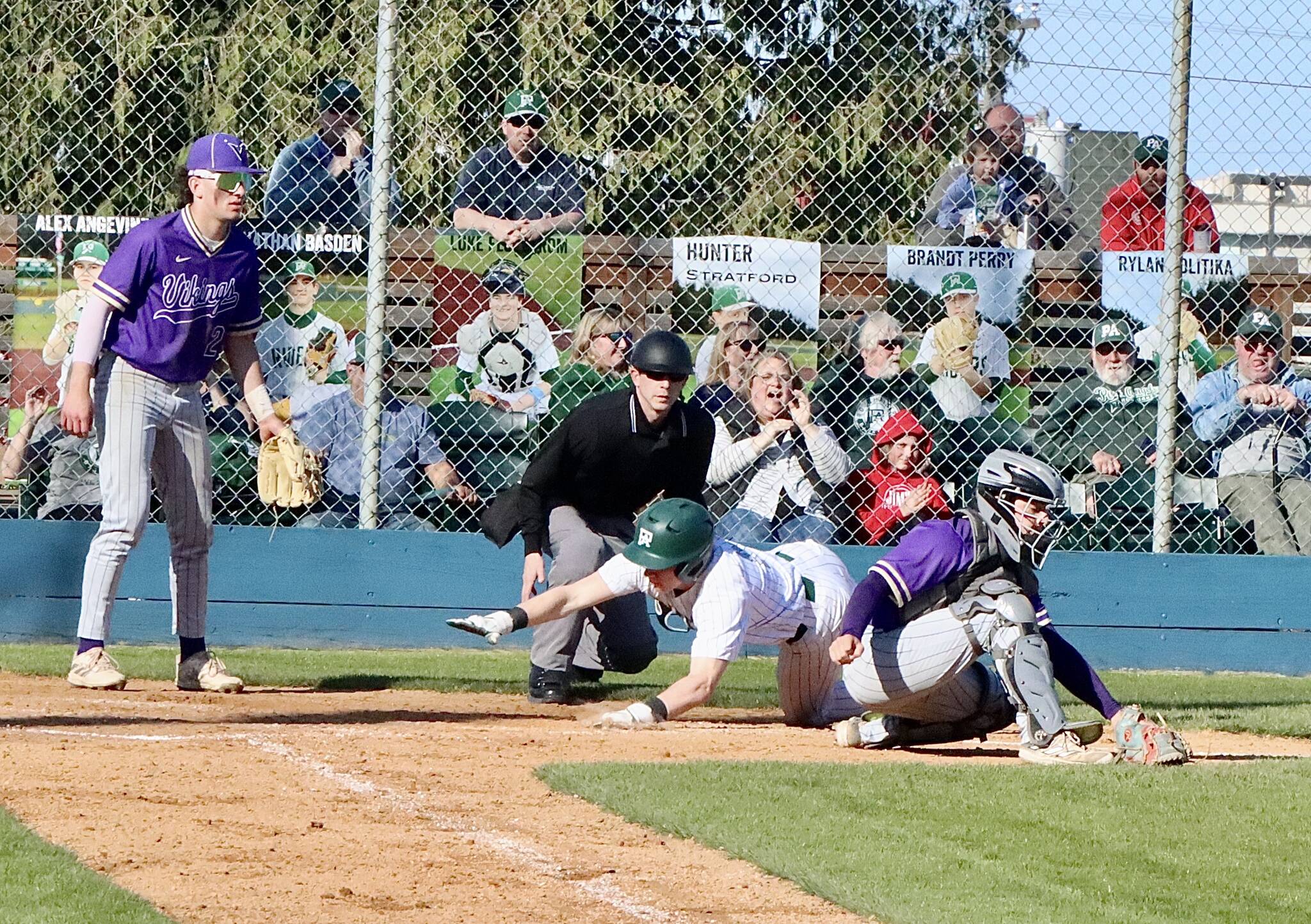 Dave Logan/for Peninsula Daily News
Port Angeles’ Trae Hanan reaches out to tag home plate before North Kitsap catcher Greyson Prichard can tag him out. He was safe for the second run of the game for the Roughriders.