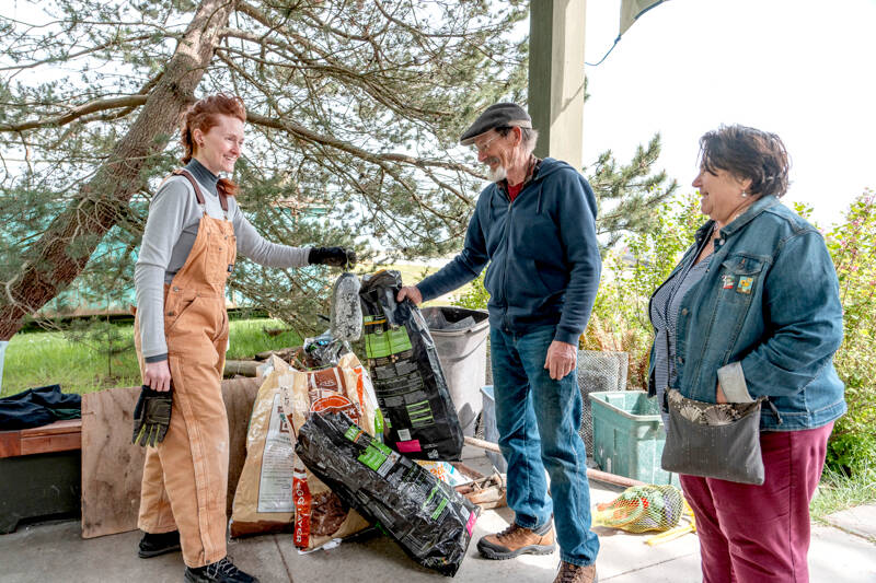 Rikki Rodger, left, holds a foam float, and Mark Stevenson and Sara Ybarra Lopez drop off 9.2 pounds of trash and debris they collected at Kai Tai Lagoon in Port Townsend during the Port Townsend Marine Science Center Earth Day Beach Cleanup event Saturday at Fort Worden State Park. (Steve Mullensky/for Peninsula Daily News)