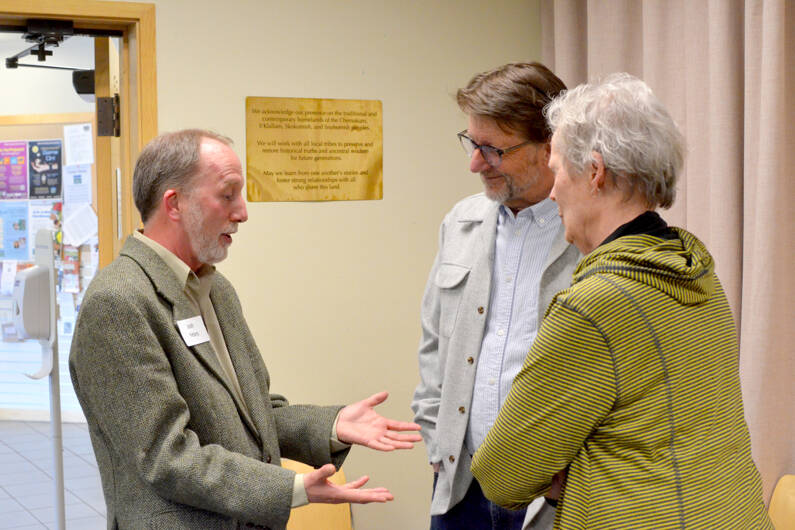 Josh Peters, left, in conversation with two attendees at Tuesday night’s event in the Humphrey room at Jefferson County Library District. (Elijah Sussman/Peninsula Daily News)