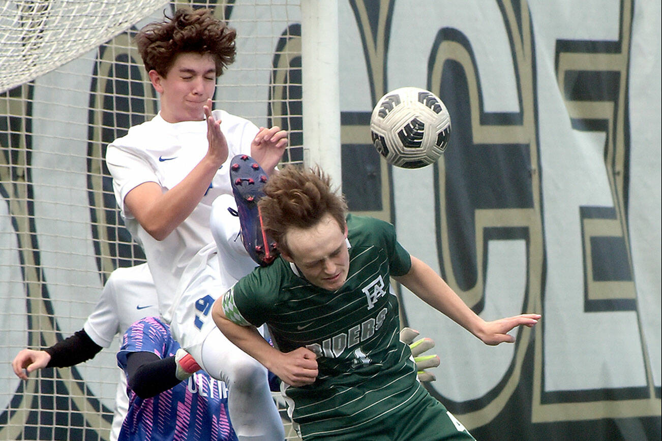 KEITH THORPE/PENINSULA DAILY NEWS
Port Angeles' Grant Butterworth, front, tries to steer an incoming corner kick as Olympic's Jackson Wyall and goalkeeper Mariano Pena defend the net during Saturday's playoff game at Peninsula College.