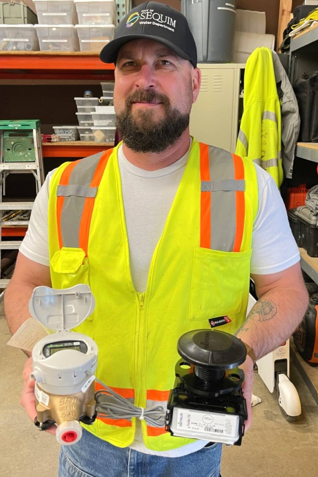 Moses McDonald, a Sequim water operator, holds one of the city’s new utility residential meters in his right hand and a radio transmitter in his left. City staff finished replacing more than 3,000 meters so they can be read remotely. (City of Sequim)