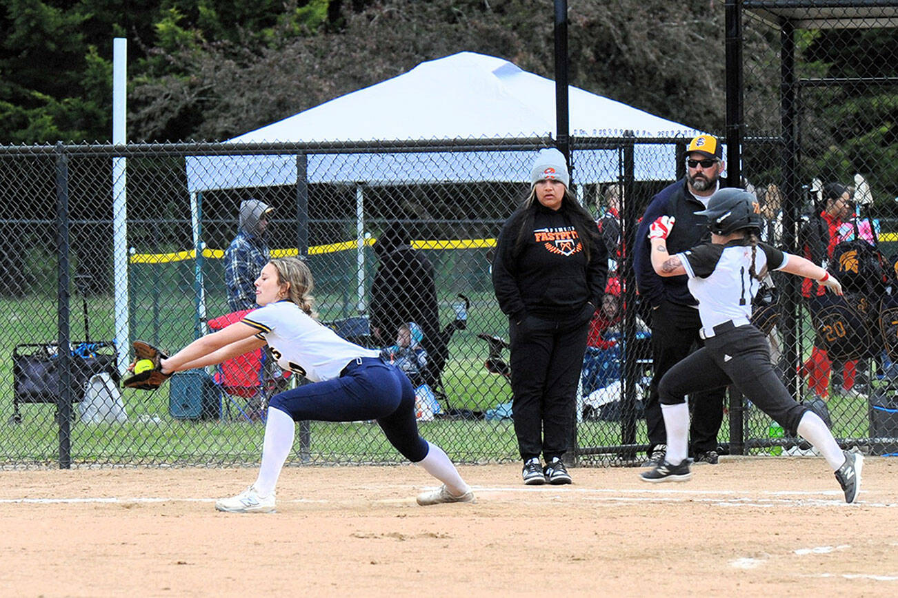 Forks’ Avery Diley takes the throw at first for the out against Rainier runner Mia Naval on Wednesday afternoon at Borst Park in Centralia during the District 4 tournament. The Spartans fell to the Mountaineers 8-7 to close out the season. (Lonnie Archibald/for Peninsula Daily News)