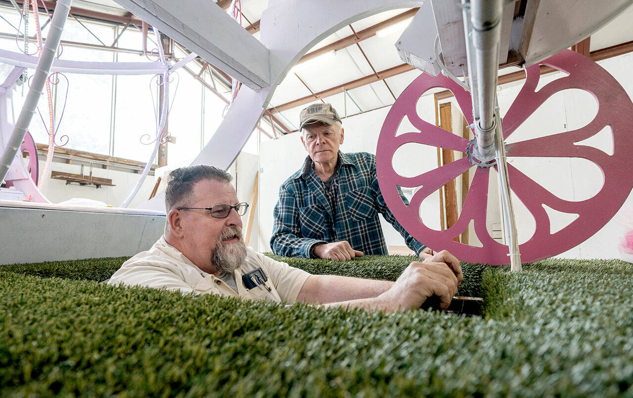 Bliss Morris of Chimacum, a float builder and driver of the Rhody float, sits in the driver’s seat on Thursday as he checks out sight lines in the 60-foot float he will be piloting in the streets of Port Townsend during the upcoming 90th Rhody Parade on Saturday. Rhody volunteer Mike Ridgway of Port Townsend looks on. (Steve Mullensky/for Peninsula Daily News)