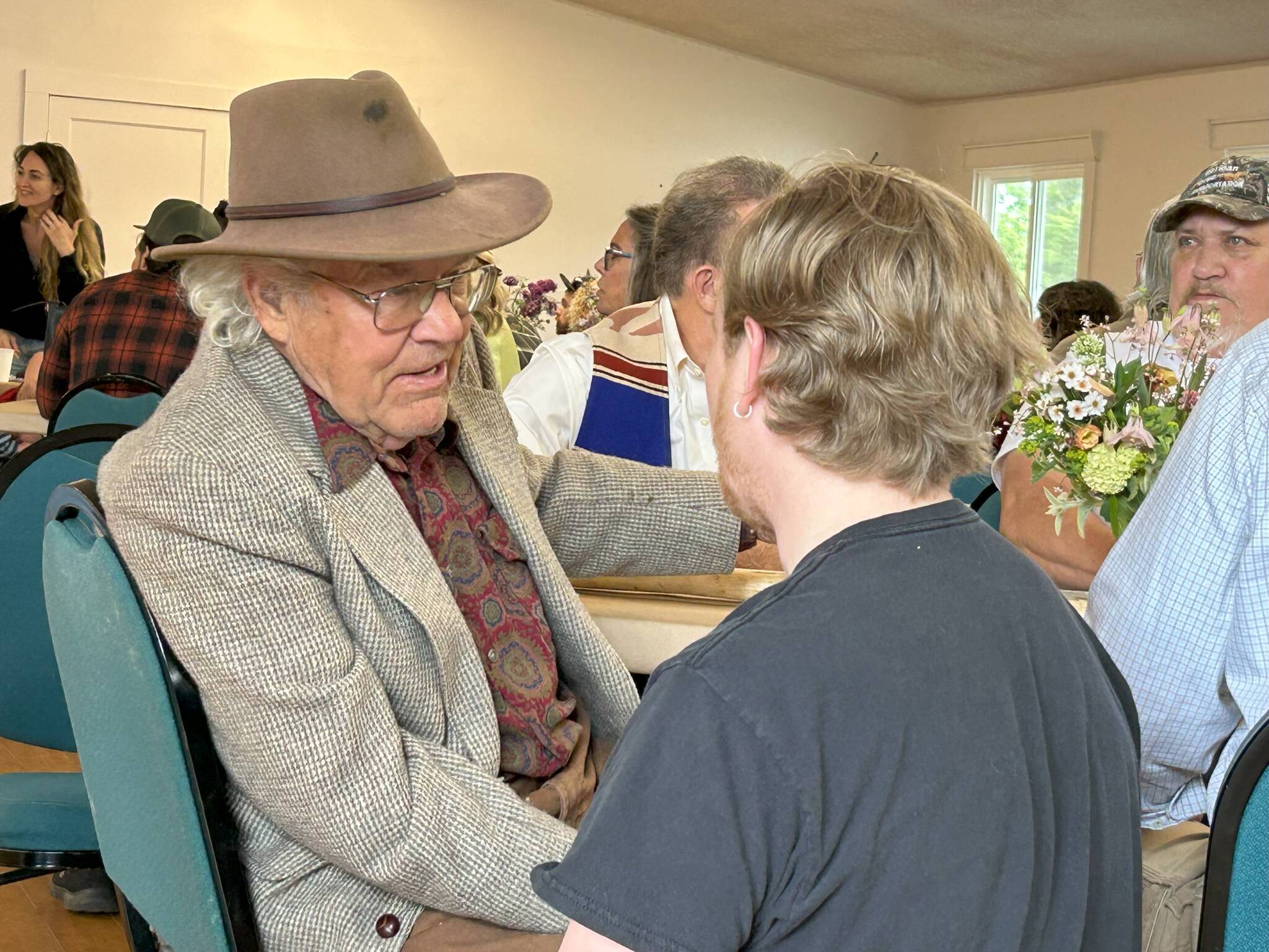 Nash Huber greets visitors during a benefit concert and dinner on May 17 in the Sequim Prairie Grange that raised funds for his medical and legal expenses. He faces eviction from Delta Farm, a Dungeness farm he helped preserve in exchange to lease it through 2032. However, Washington Farmland Trust reports that Huber continues to have violations going against his lease agreement. (Matthew Nash/Olympic Peninsula News Group)
