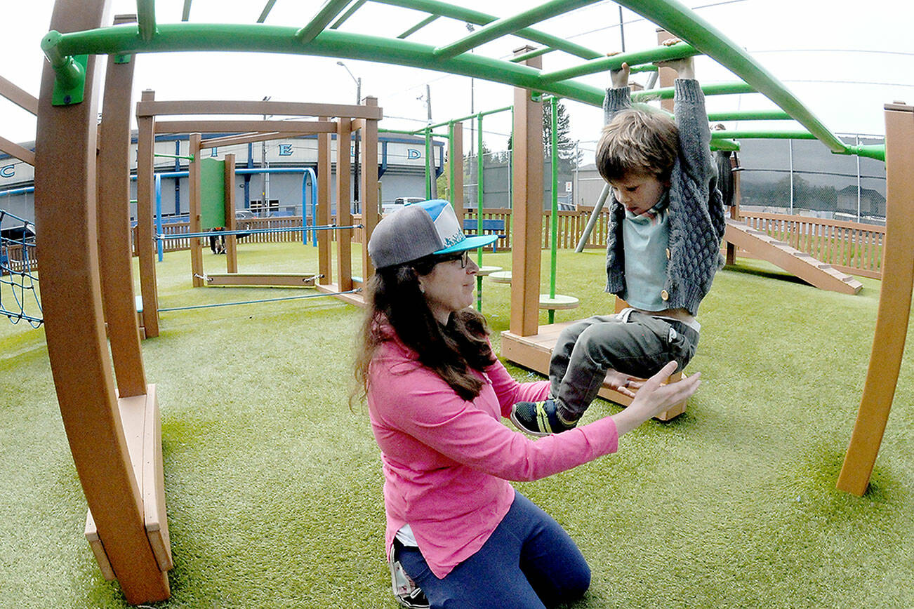 Elizabeth Angell of Port Angeles keeps watch on her son, Myles Angell, 2, during an outing at the Dream Playground at Erickson Playfield on Wednesday in Port Angeles. Portions of the playground are currently closed for maintenance and the entire playground is scheduled to be closed on Saturday morning for seasonal play surface rehabilitation. (Keith Thorpe/Peninsula Daily News)