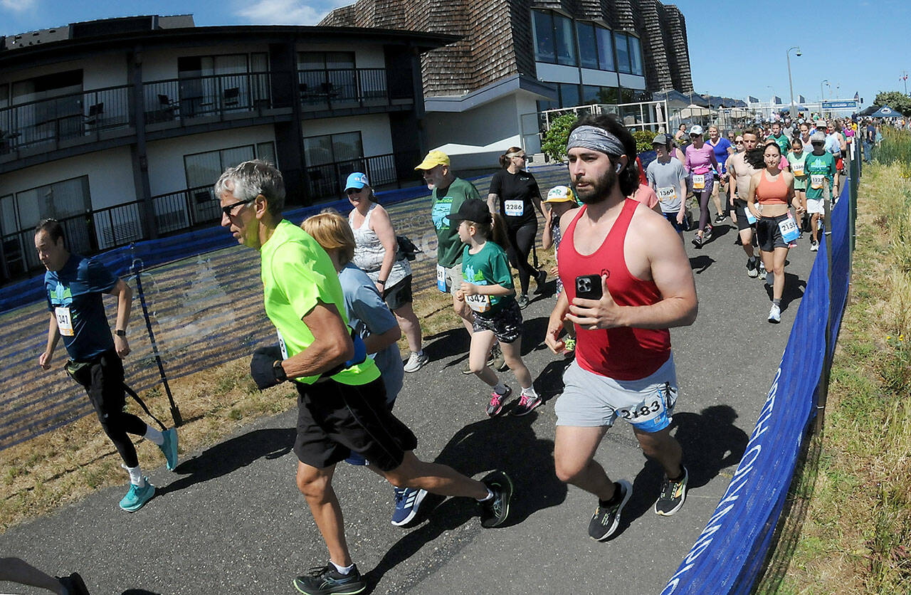 KEITH THORPE/PENINSULA DAILY NEWS Runners take off from the start of Saturday’s combined 5k and 10k races of the Olympic Discovery Marathon along the Waterfront Trail from Port Angeles City Pier,