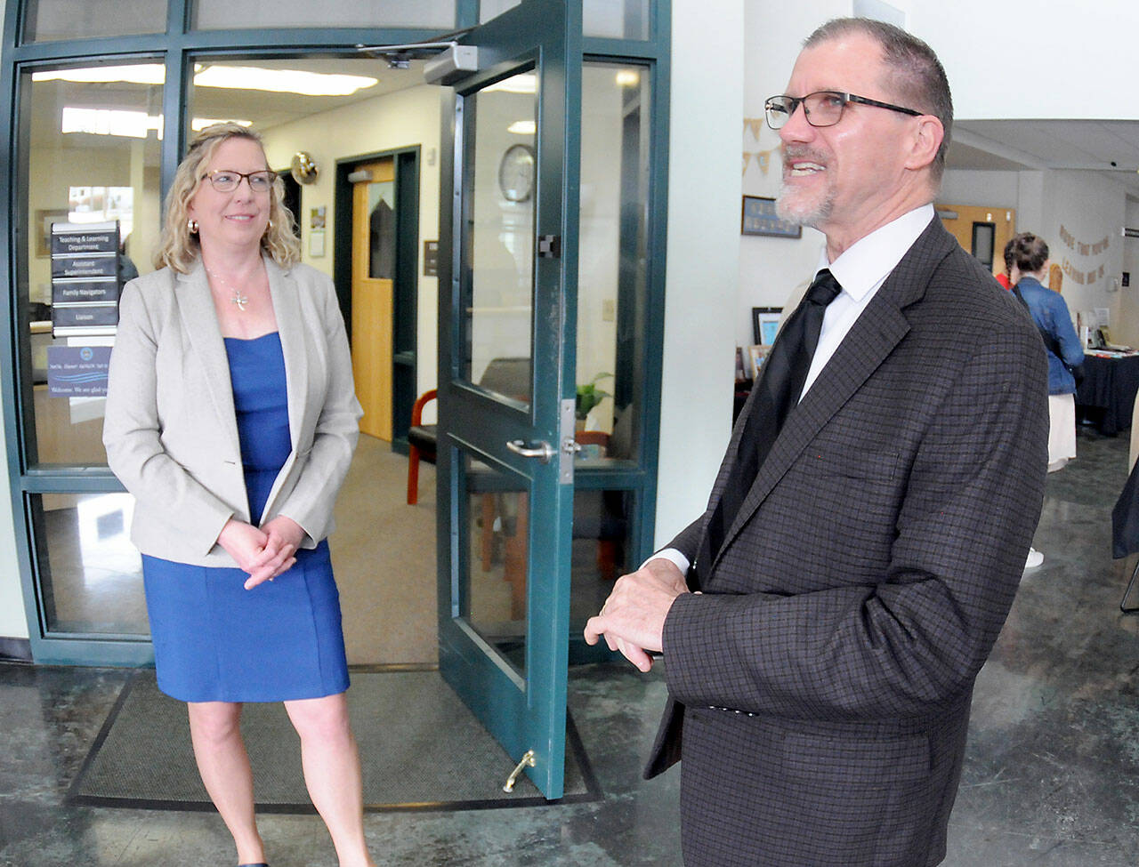 Retiring Port Angeles School District Superintendent Marty Brewer, right, shares a career experience as his replacement, Michelle Olsen, listens during a retirement gathering on Thursday at Lincoln Center in Port Angeles. (Keith Thorpe/Peninsula Daily News)
