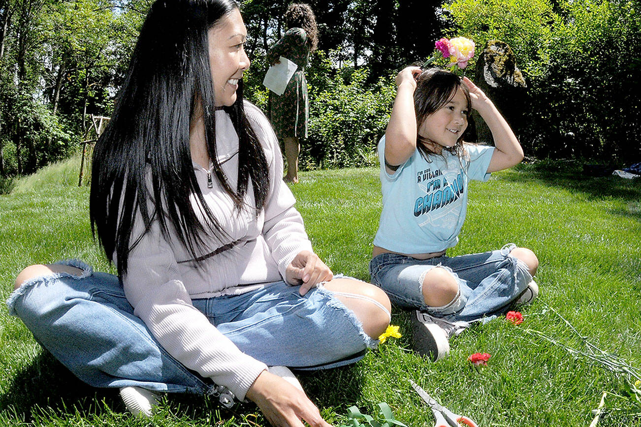 Juliet Shidler, 6, tries on a flower-adorned headband she made with her mother, Rachel Shidler of Port Angeles, during Saturday’s Summertide celebration in Webster’s Woods sculpture park at the Port Angeles Fine Arts Center. The event, which marks the beginning of the summer season, featured food, music, crafts and other activities for youths and adults. (Keith Thorpe/Peninsula Daily News)