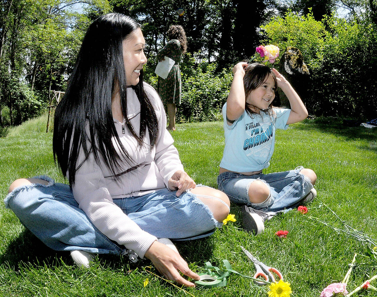Juliet Shidler, 6, tries on a flower-adorned headband she made with her mother, Rachel Shidler of Port Angeles, during Saturday’s Summertide celebration in Webster’s Woods sculpture park at the Port Angeles Fine Arts Center. The event, which marks the beginning of the summer season, featured food, music, crafts and other activities for youths and adults. (Keith Thorpe/Peninsula Daily News)