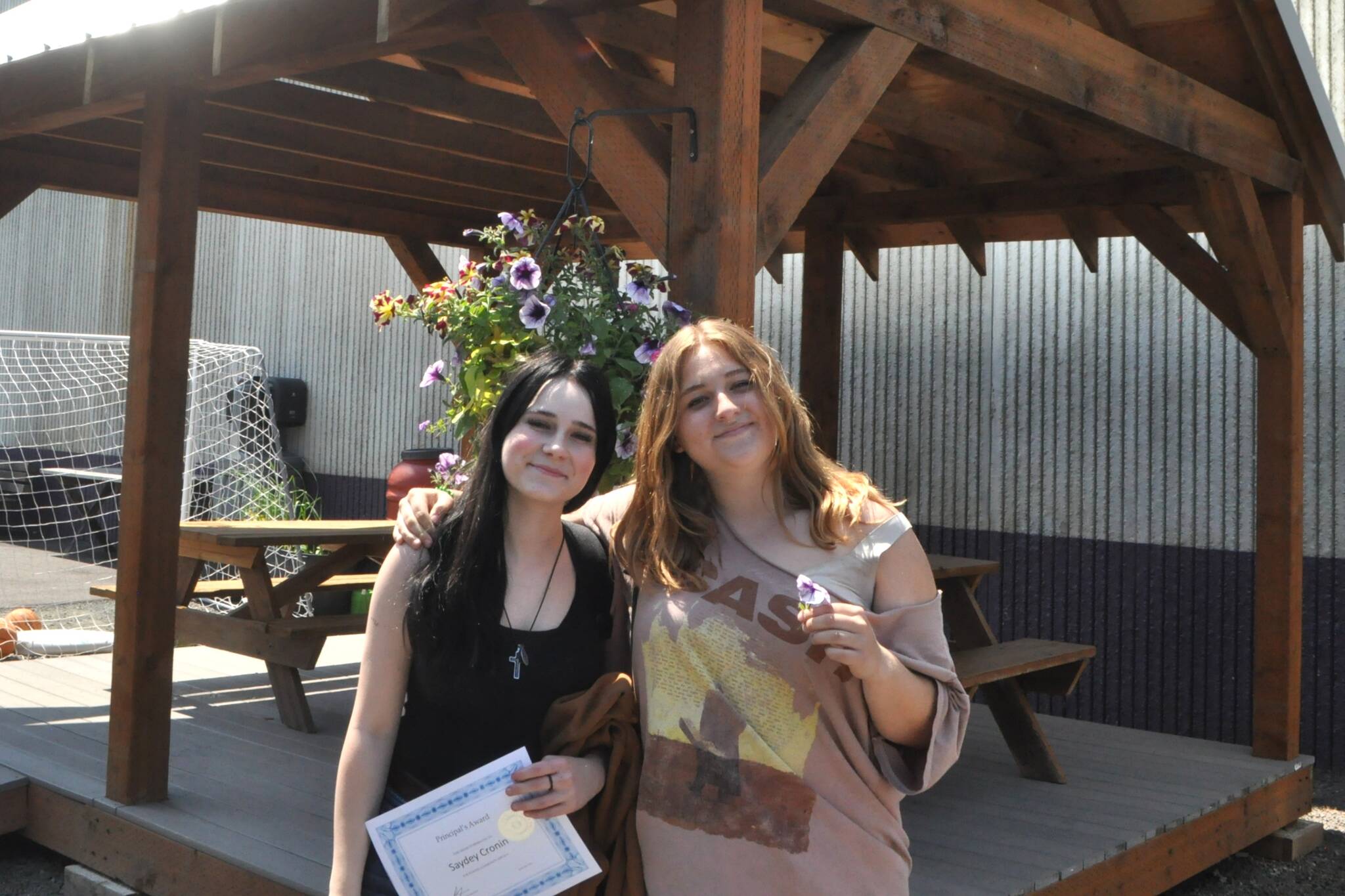 Eighth-graders Saydey Cronin and Madelyn Bower stand by a gazebo they and 58 other students helped to build through their Sequim Middle School Core Plus Instruction industrial arts class. The friends were two of a handful of girls to participate in the building classes. (Matthew Nash/Olympic Peninsula News Group)